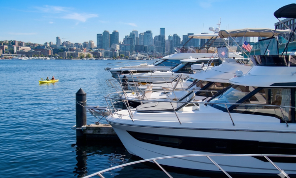 Boats lined up at Sundance Yachts Seattle Marina on Lake Union with the downtown Seattle skyline in the background