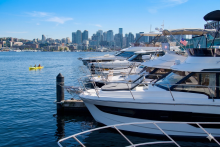 Boats lined up at Sundance Yachts Seattle Marina on Lake Union with the downtown Seattle skyline in the background